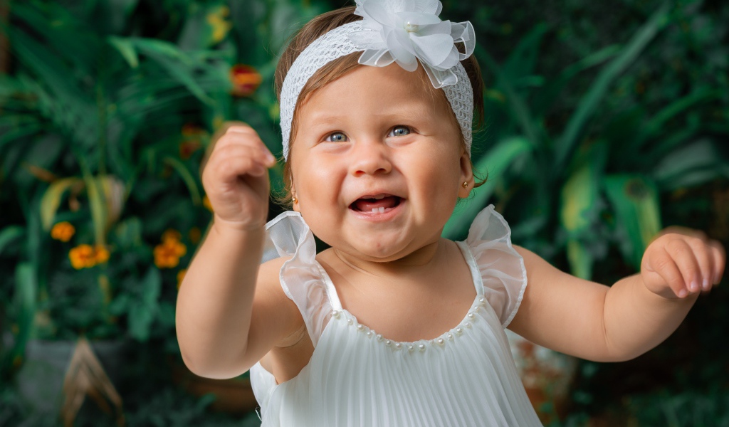 Красивая маленькая девочка в белом платье 