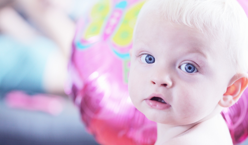 Голубоглазый маленький мальчик на фоне шарика