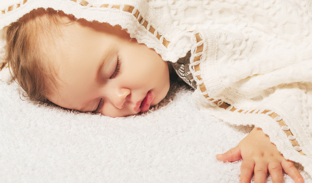 Милый спящий ребенок под покрывалом 