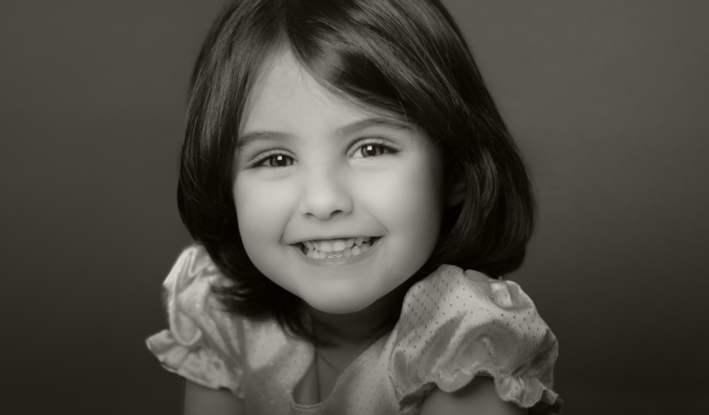 Милая улыбающаяся маленькая девочка черно-белое фото