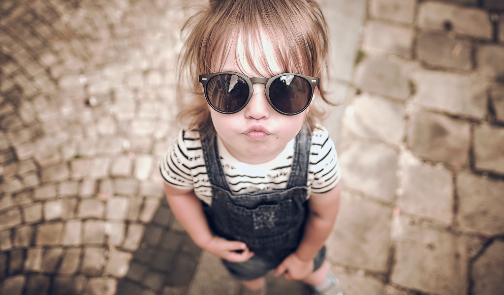 Модная маленькая девочка в черных очках