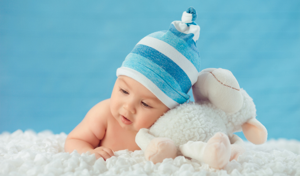 Забавный малыш с игрушкой на голубом фоне