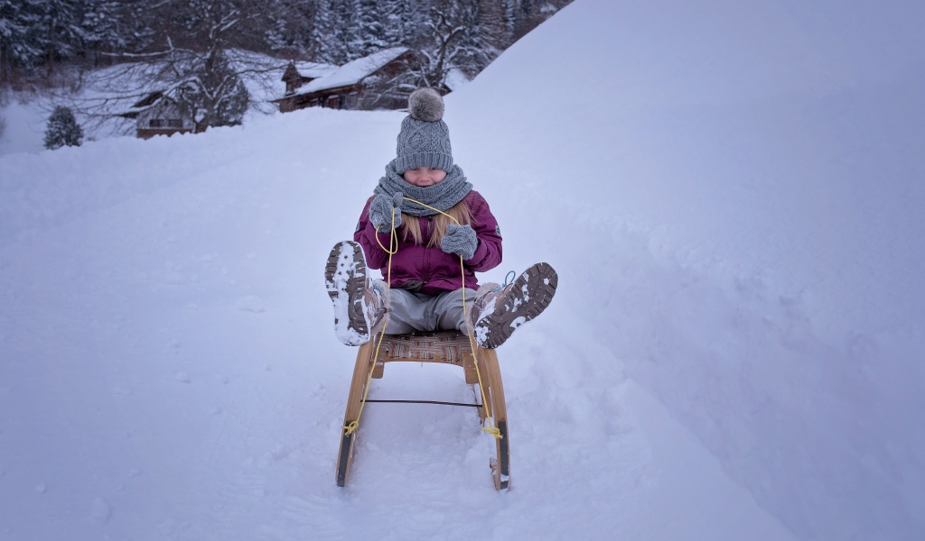 Девочка едет на санках с горки