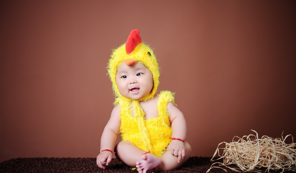 Маленький мальчик азиат в костюме цыпленка