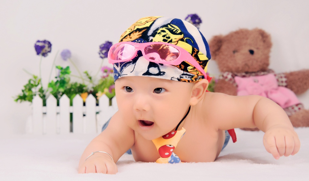 Маленький ребенок азиат в шапке с очками