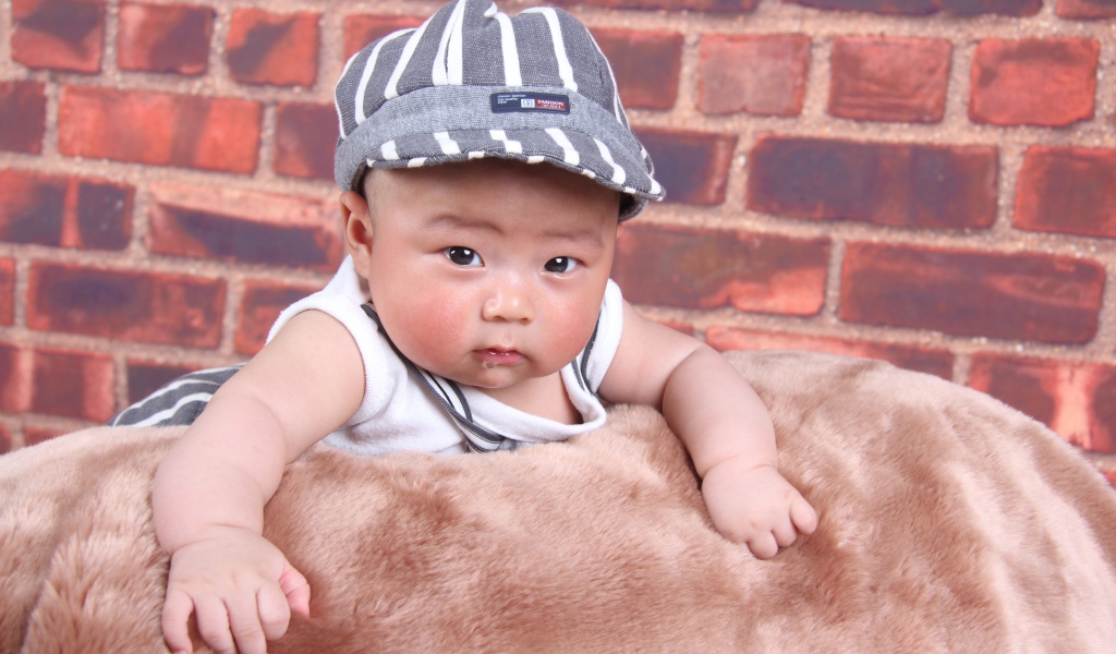 Маленький азиатский ребенок на фоне стены