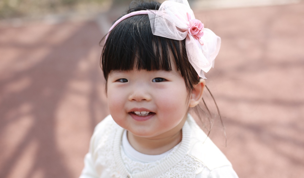 Маленькая девочка азиатка с бантом на голове 