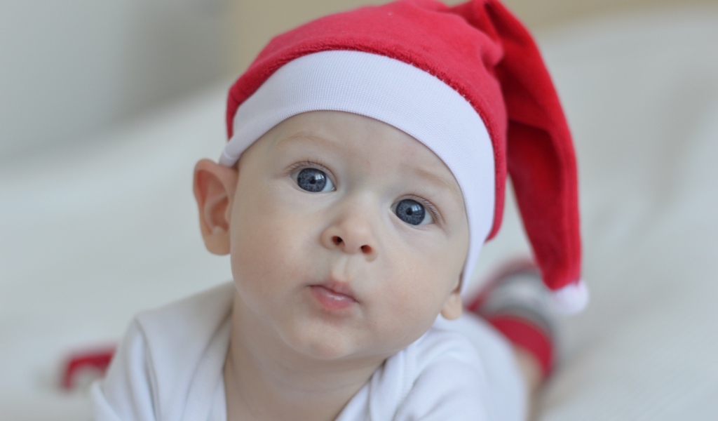 Маленький голубоглазый мальчик в красной шапке Санты