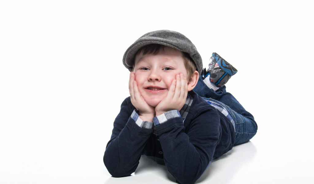 Маленький мальчик в кепке на белом фоне