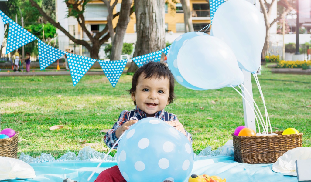 Маленький мальчик с шарами и украшениями на день рождения 