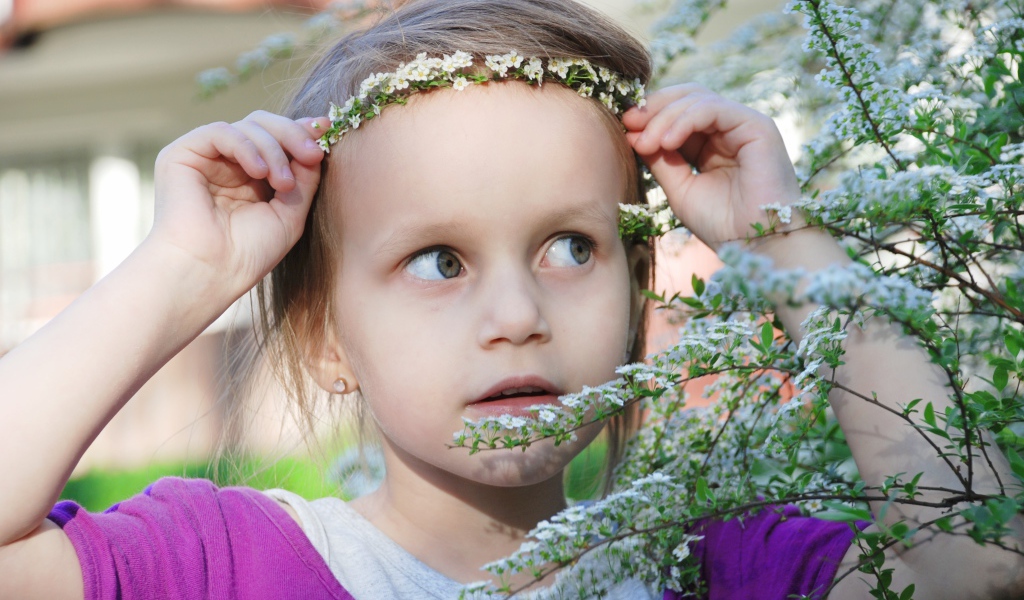 Маленькая девочка украсила голову белым цветком 