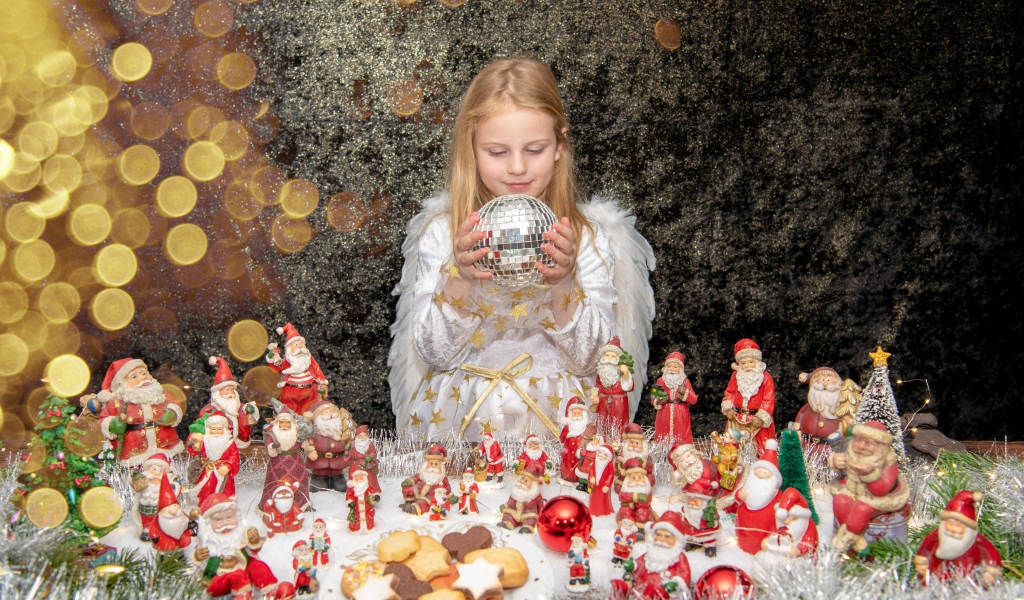 Маленькая девочка в костюме ангела с новогодним декором