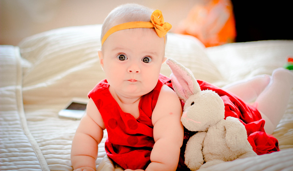 Маленькая девочка в красном платье с игрушкой 