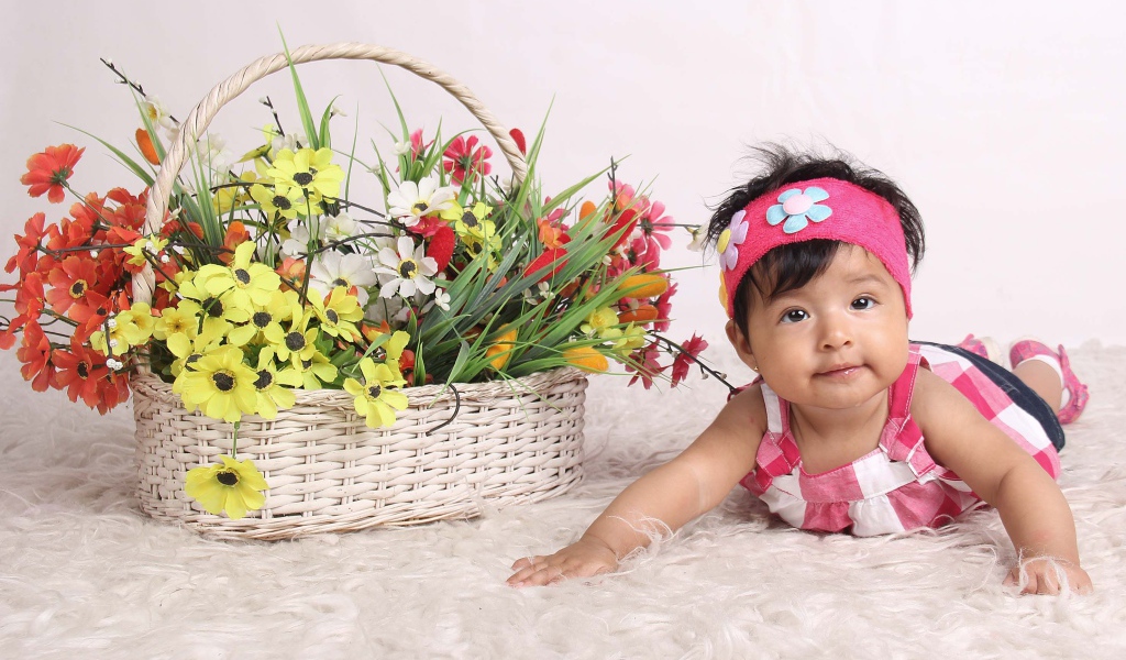Маленькая девочка рядом с корзиной цветов 