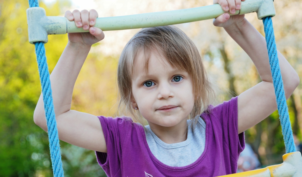 Маленькая девочка на подвесной лестнице 