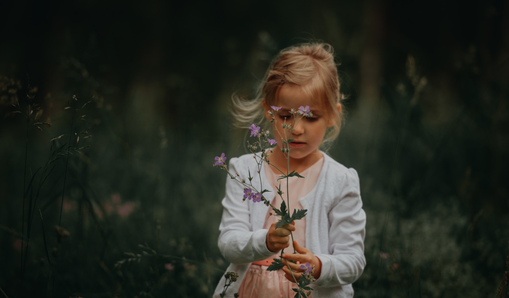 Маленькая девочка с полевым цветком в руке