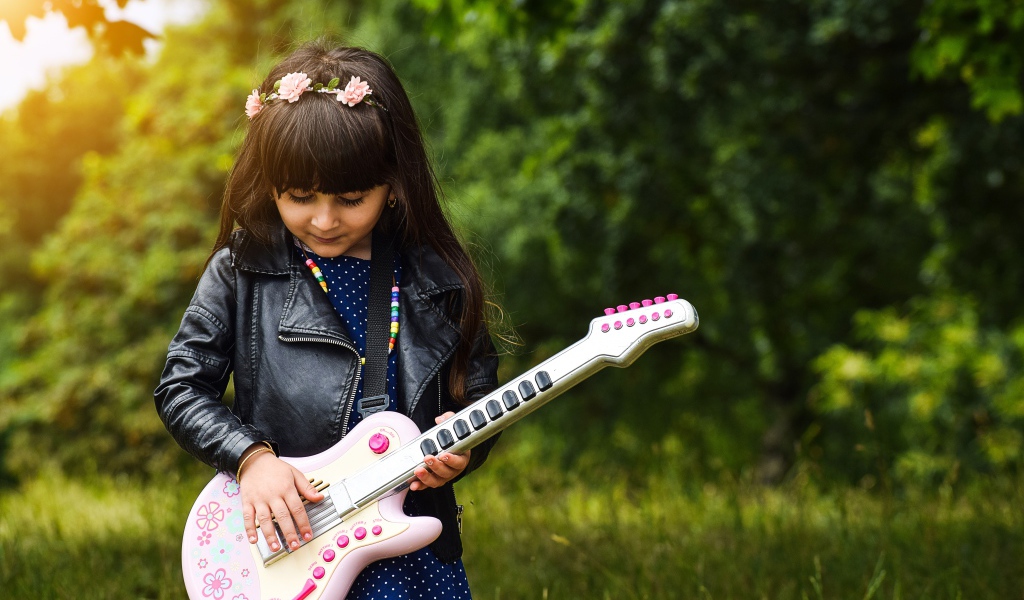 Маленькая девочка с игрушечной гитарой