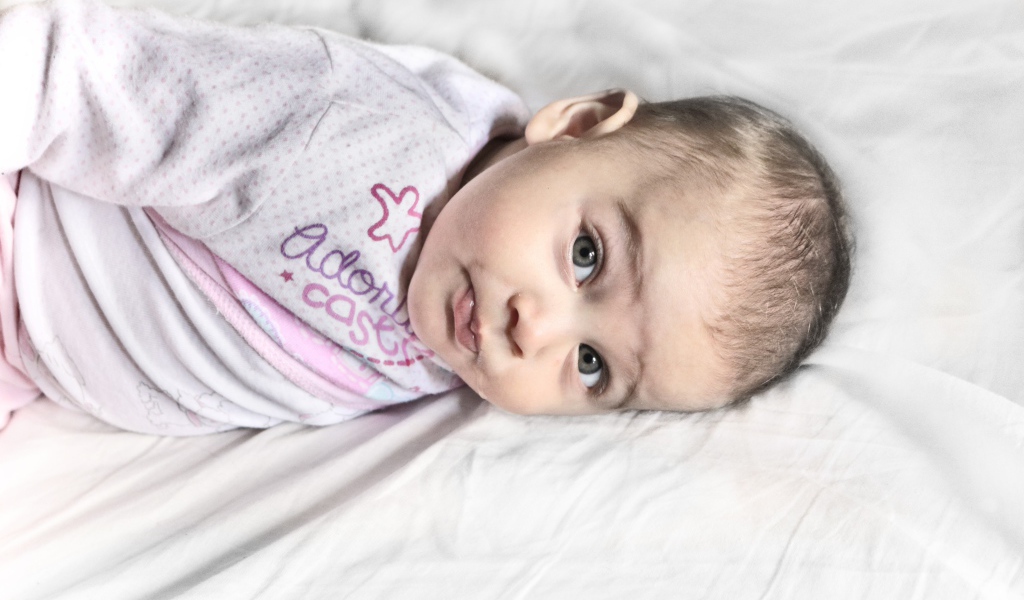 Маленький новорожденный ребенок лежит на кровати 