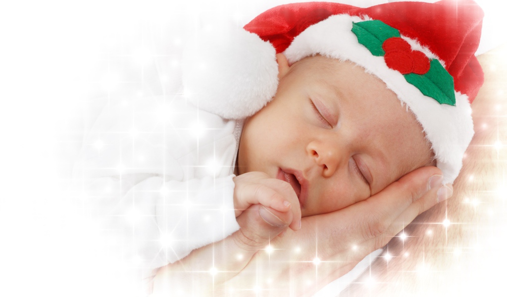Маленький спящий ребенок в новогодней шапке 