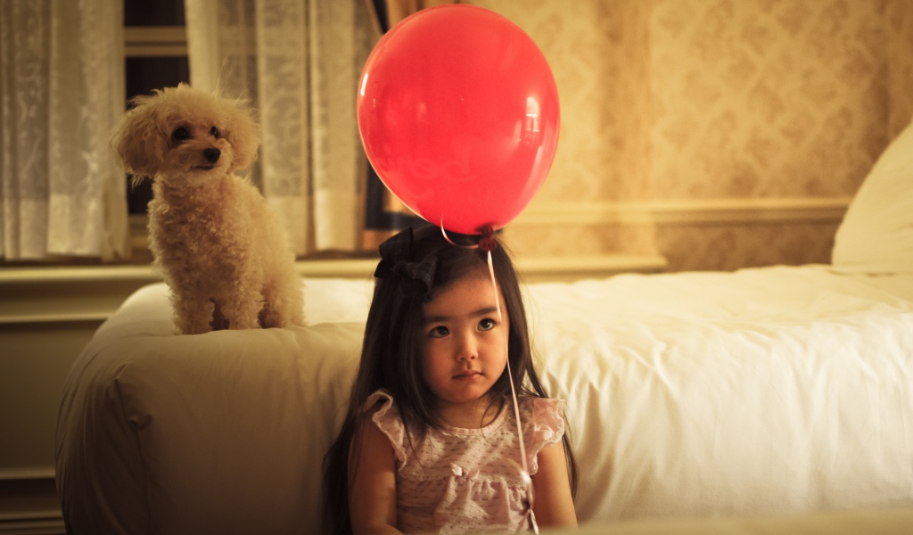 Грустная девочка азиатка с красным шариком