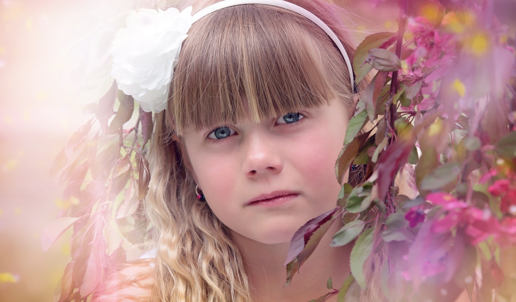 Грустная маленькая девочка у ветки дерева 