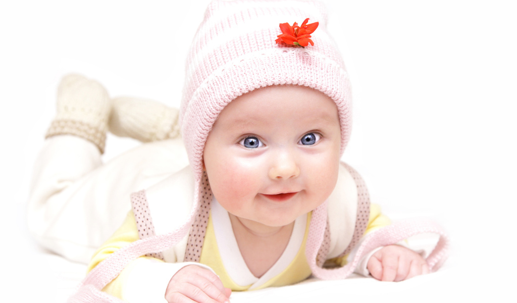 Улыбающийся голубоглазый ребенок в шапке 