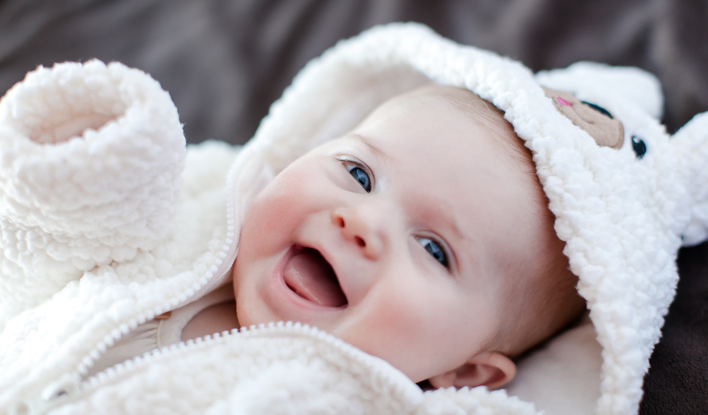 Улыбающийся милый ребенок в теплом костюме 