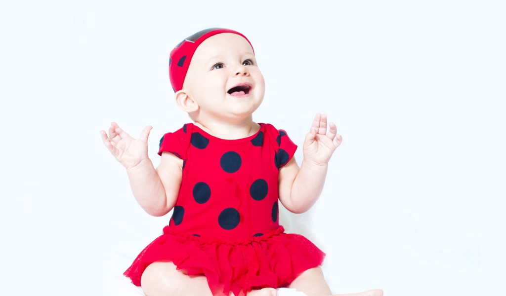 Улыбающаяся девочка в красном платье с черными кругами