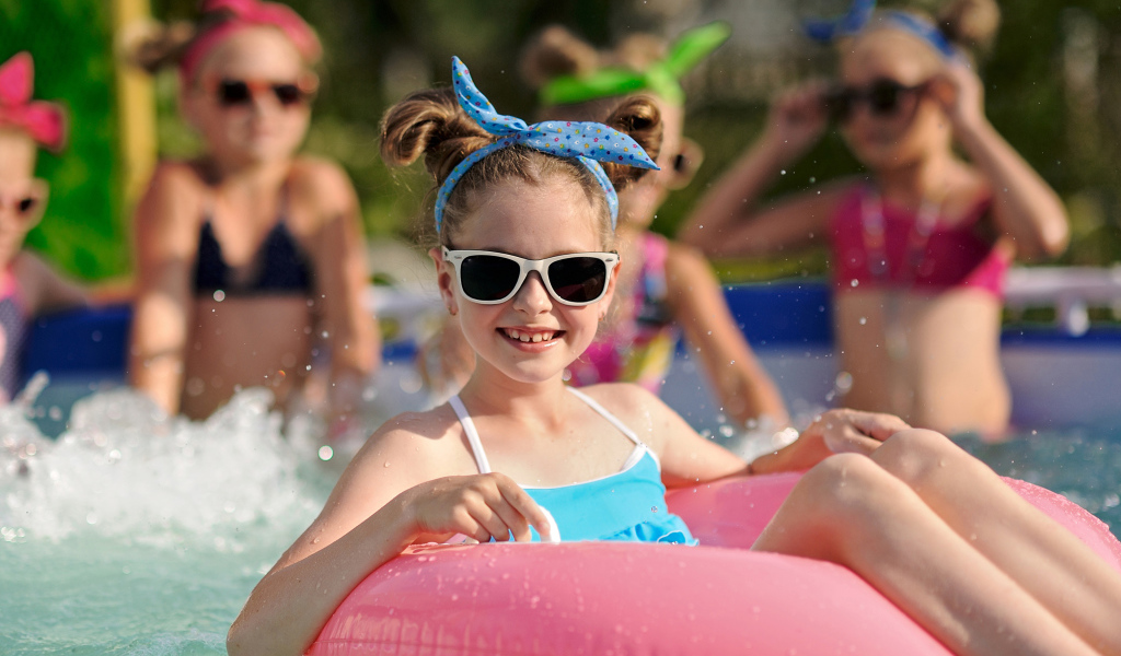 Улыбающаяся девочка со спасательным кругом в бассейне 