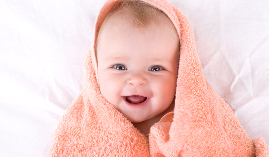 Улыбающийся грудной ребенок в полотенце