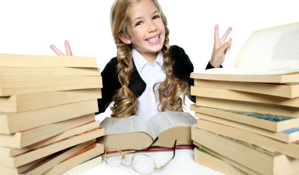 Улыбающаяся девочка школьница с книгами на белом фоне