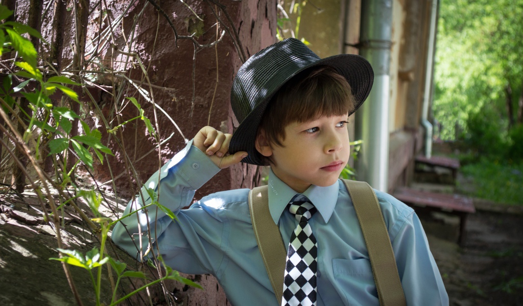 Стильный мальчик в черной шляпе 