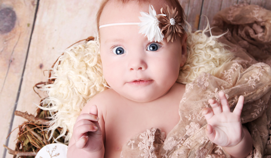 Удивленная голубоглазая новорожденная девочка 