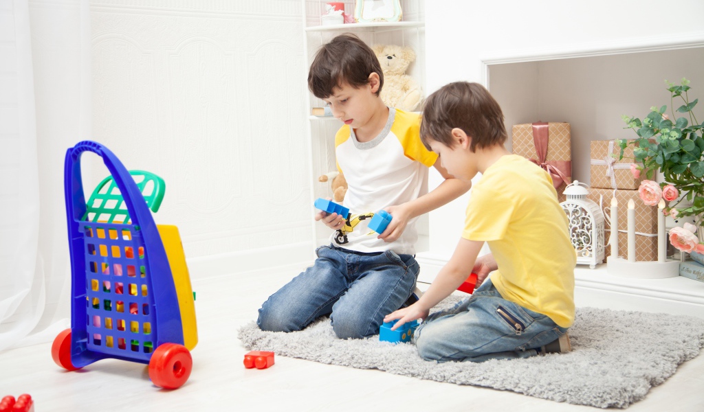 Два маленьких мальчика играет на полу