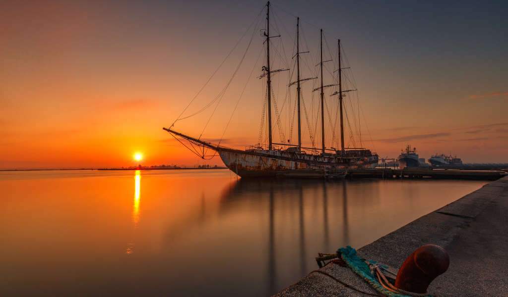 Большой корабль стоит на закате солнца 