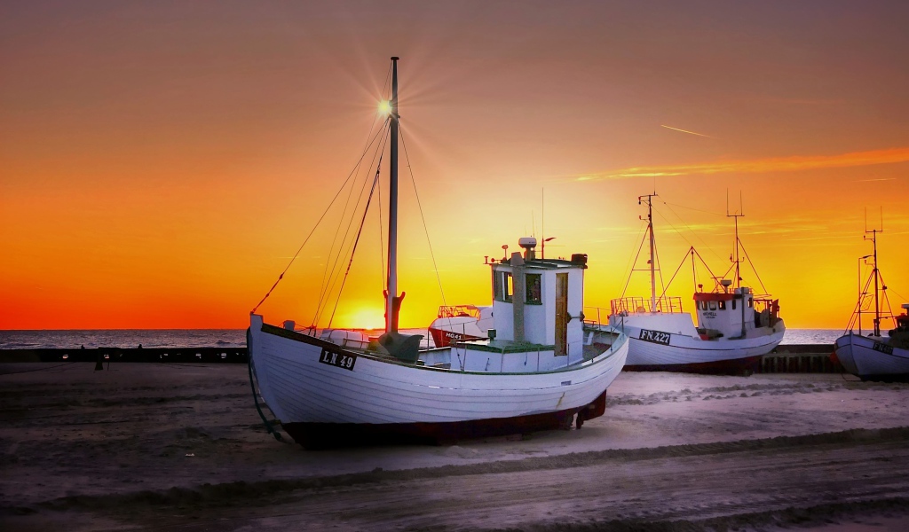 Рыбацкая лодка на берегу на закате 