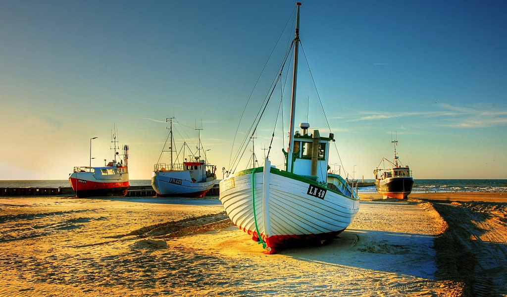 Рыболовные лодки в лучах солнца на берегу 