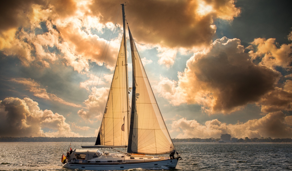 Большая парусная яхта в море на закате 