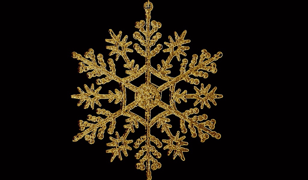 Золотая снежинка на черном фоне 