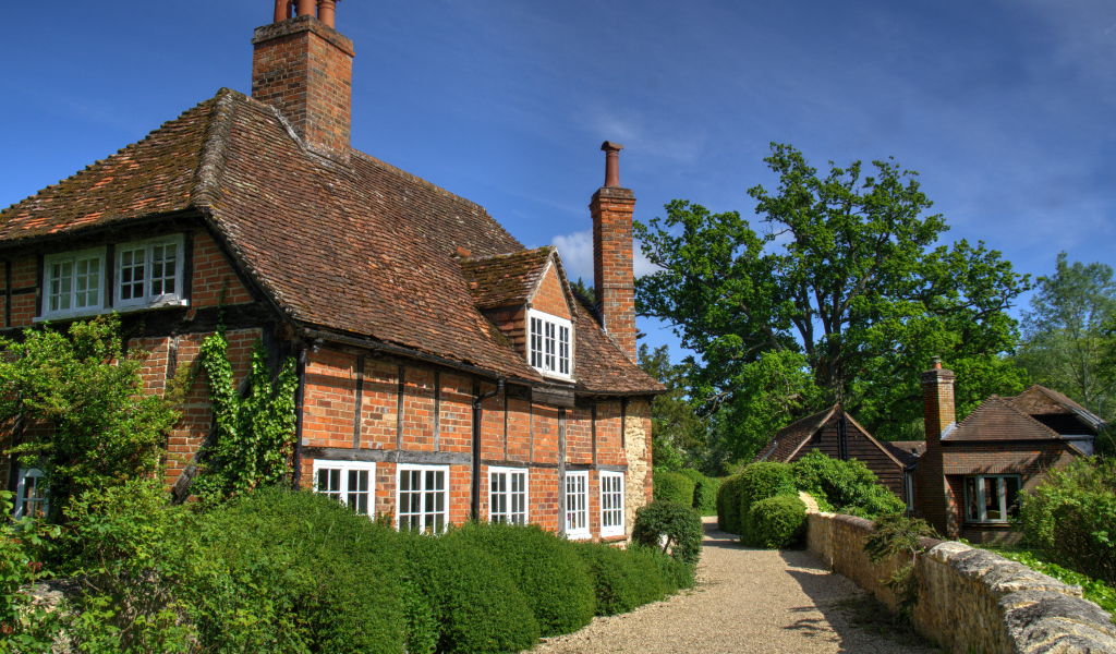 Кирпичный старый дом под голубым небом, Англия 