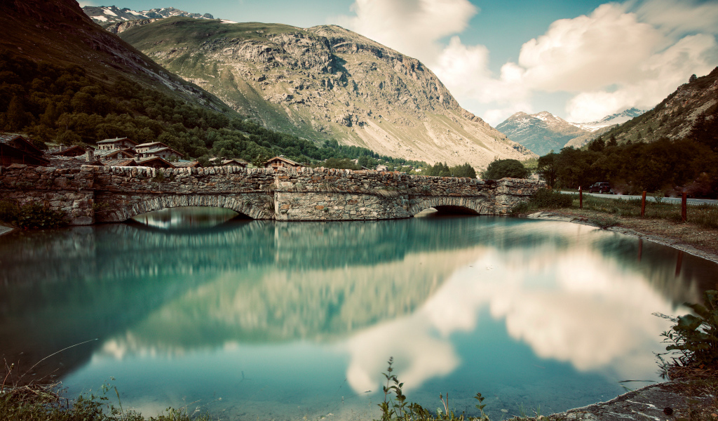 Старый кирпичный мост на озере у горы,Франция