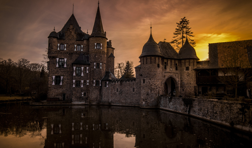 Старинный замок у озера в сумерках, Германия