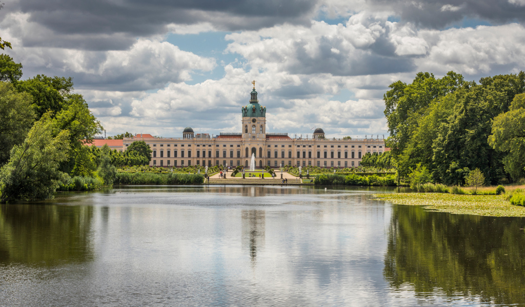 Красивый вид на замок Шарлоттенбург у озера под белыми облаками