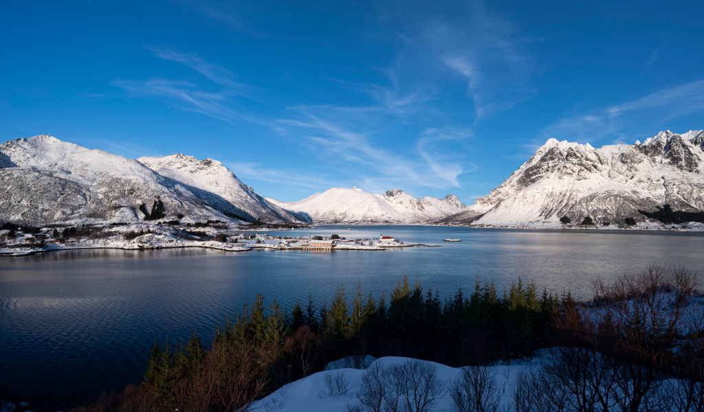 Покрытые снегом горы под голубым небом у воды, Норвегия