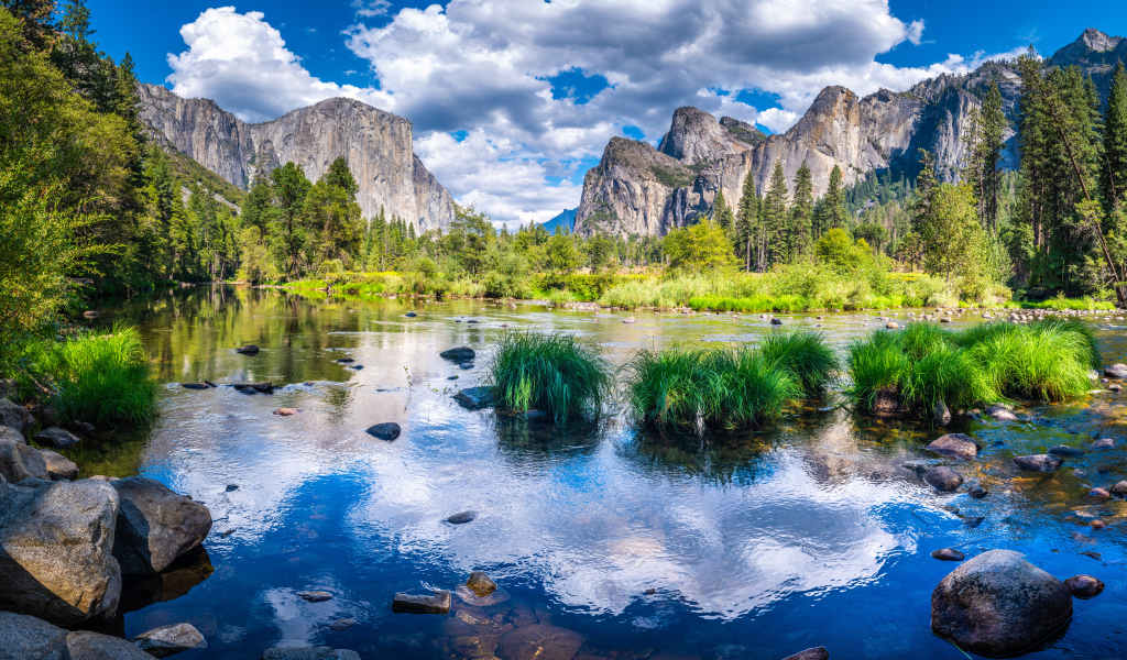 Спокойная вода в озере на фоне гор под белыми облаками, США 