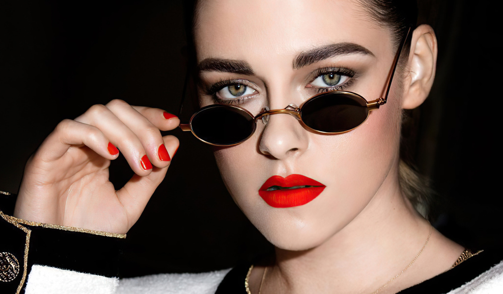 Актриса Кристен Стюарт в очках на  черном фоне