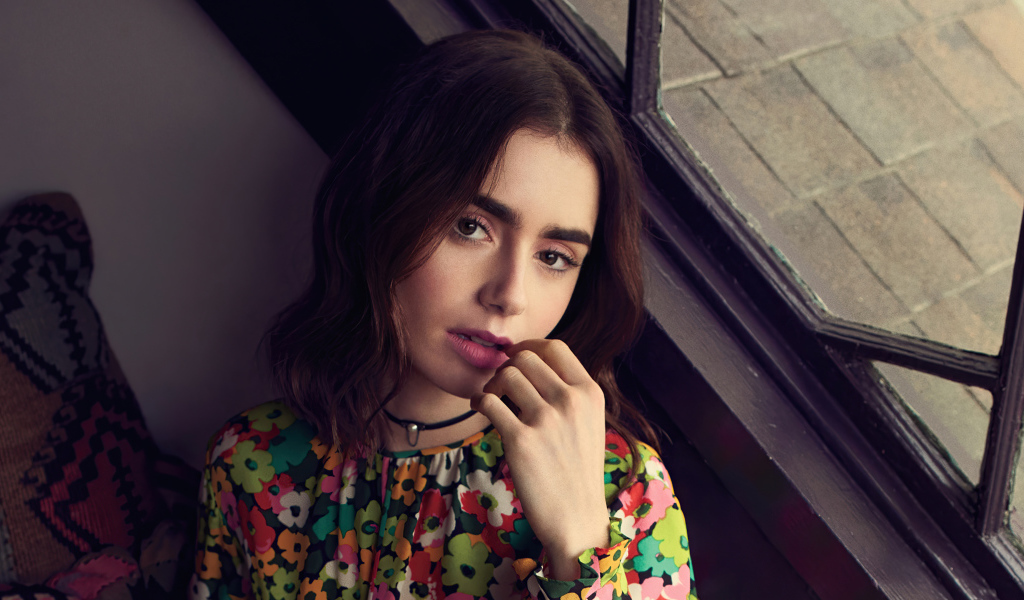 Актриса Лили Коллинз сидит у окна