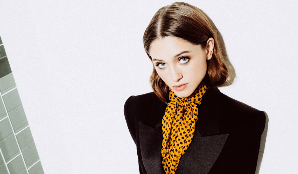 Актриса Наталия Дайер в черном пиджаке на белом фоне