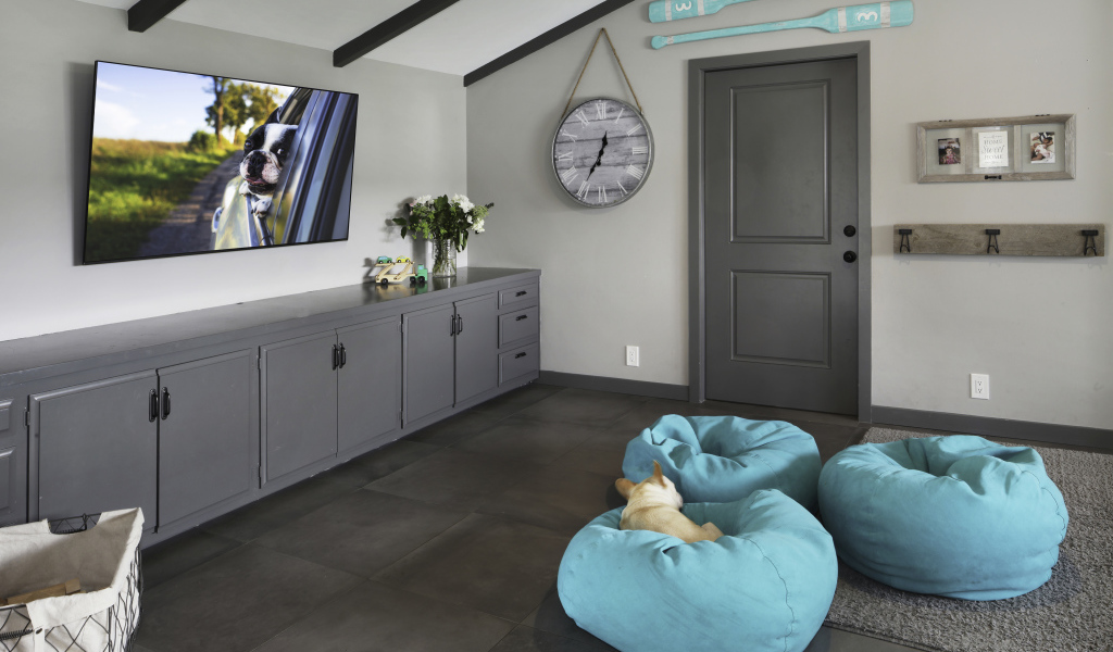 Голубые кресла в комнате с большим телевизором 