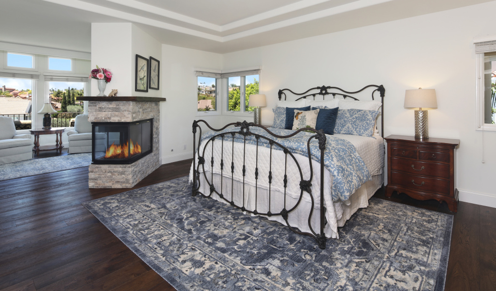 Уютная спальная комната с камином и большой кроватью
